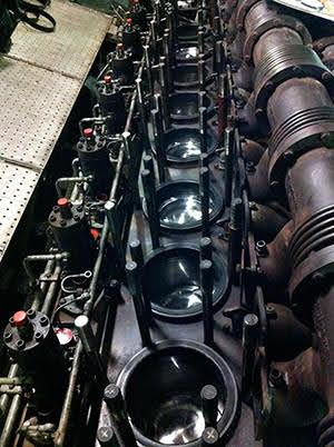 Pistons seated in the bores of an inline diesel engine during overhaul and reassembly