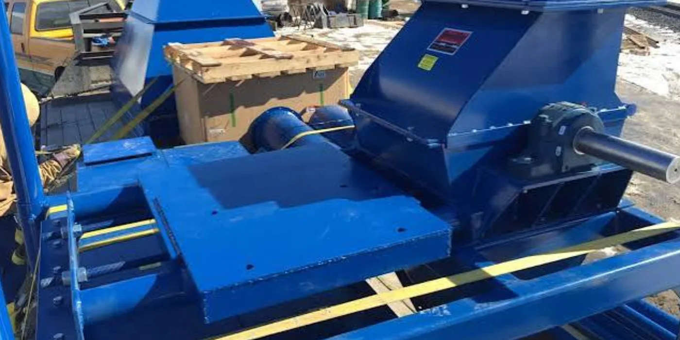 Fabricated industrial hammer mill with feed hopper and gearbox drive, mounted on a steel frame