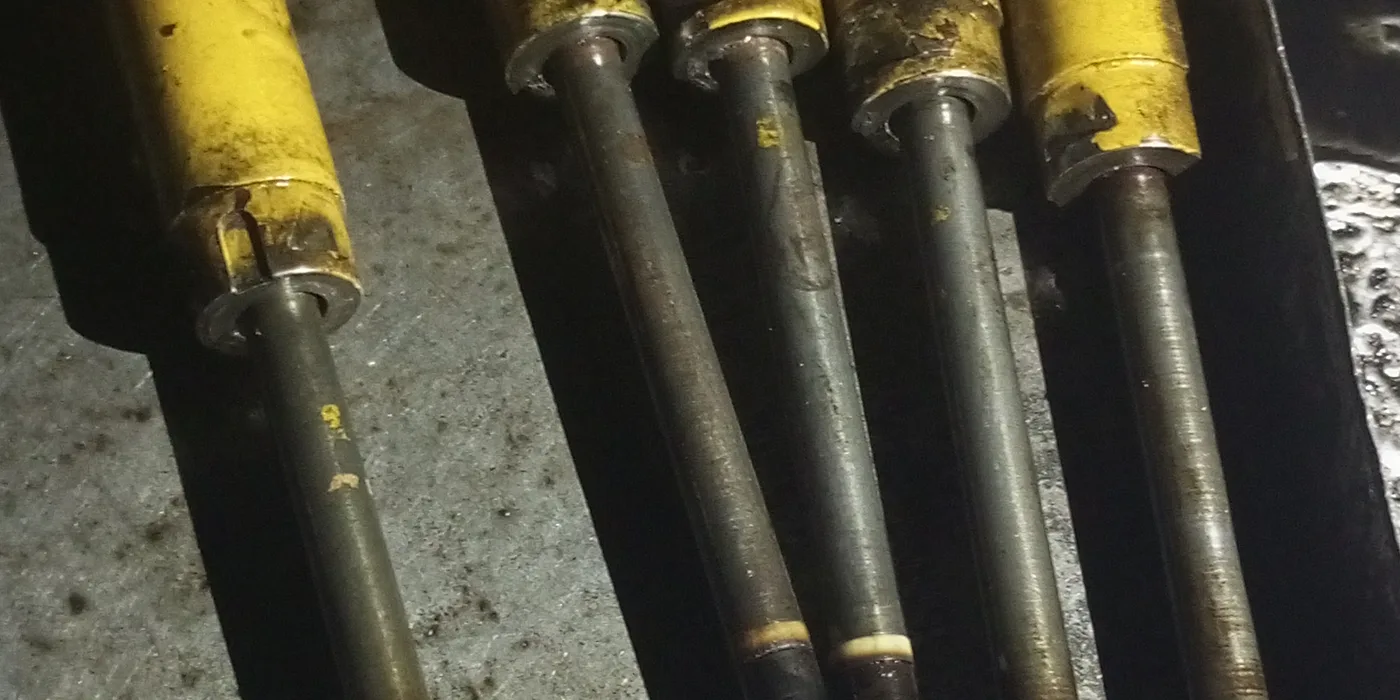 Row of diesel fuel injectors removed from a generator engine and laid out on the bench for testing at EmersonEIMS