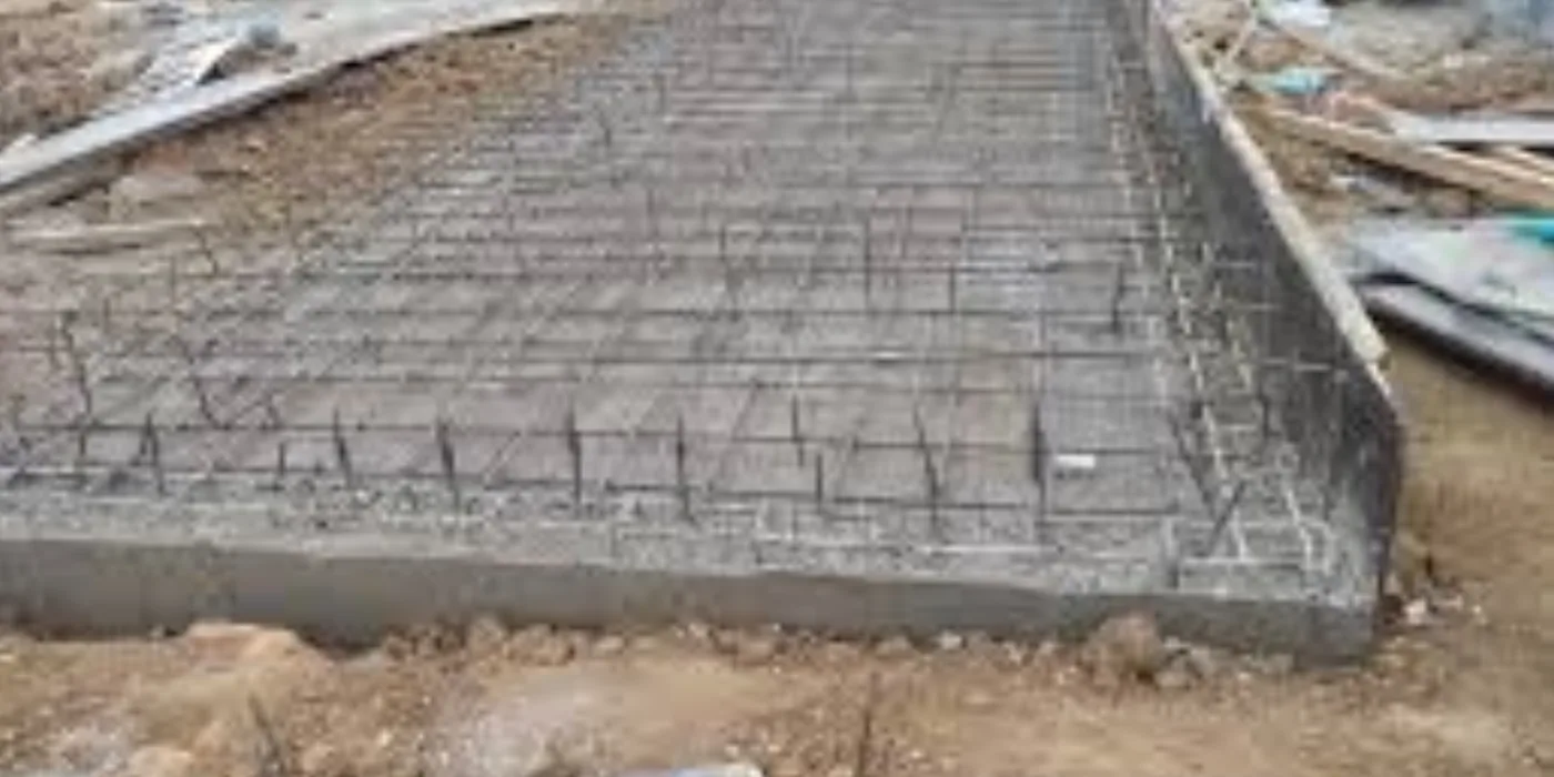 Freshly cast reinforced concrete generator plinth showing the embedded steel reinforcement grid and formed edges